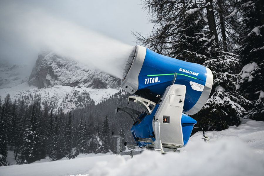 DEMACLENKO TITAN fan snow gun making snow below a rocky Alpine peak