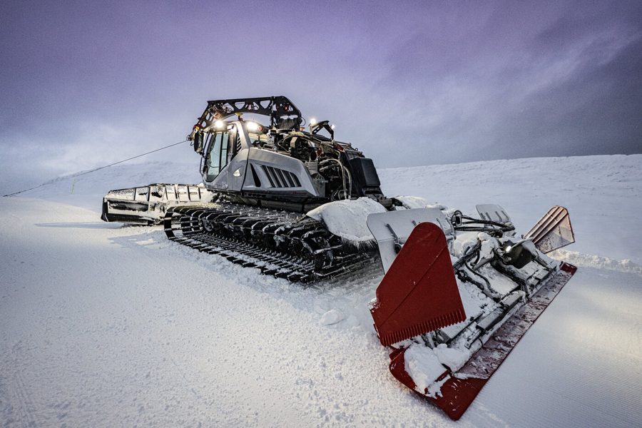 PRINOTH LEITWOLF winch groomer grooming a slope at dusk